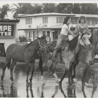 Girls Ride on Horses Through Flood Waters